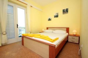 a bedroom with a bed with yellow towels on it at Rooms with a swimming pool Cavtat, Dubrovnik - 5222 in Cavtat