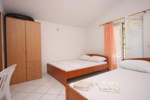 um quarto com 2 camas, um armário e uma cadeira em Apartments by the sea Podaca, Makarska - 6745 em Podaca