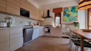 a kitchen with white cabinets and a table with chairs at Villa Duino Trieste Reception in Duino