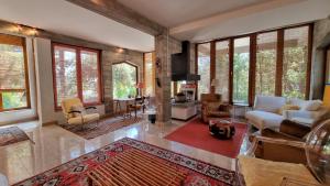 uma sala de estar com um sofá, cadeiras e janelas em Villa Duino Trieste Reception em Duino