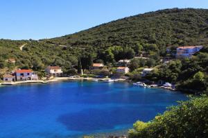 a large blue river with houses and a mountain at Seaside holiday house Cove Rogacic, Vis - 8886 in Vis