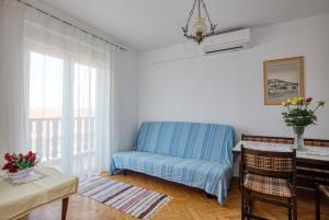 un soggiorno con sedia blu e finestra di Apartments and rooms by the sea Tisno, Murter - 5128 a Tisno (Stretto)