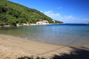 a beach with a house in the middle of the water at Secluded fisherman's cottage Cove Stoncica, Vis - 8894 in Kut +12 photos