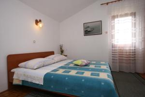Schlafzimmer mit einem Bett und einem Fenster in der Unterkunft Apartments by the sea Starigrad, Paklenica - 6579 in Starigrad-Paklenica