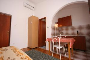 eine Küche mit einem Tisch und Stühlen im Zimmer in der Unterkunft Apartments by the sea Starigrad, Paklenica - 6579 in Starigrad-Paklenica