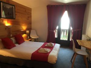 een slaapkamer met een bed, een tafel en een raam bij Hôtel Valentin in Les Deux Alpes