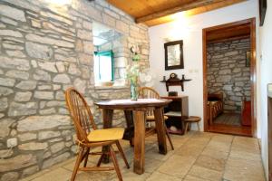 une salle à manger aux murs de pierre avec une table et des chaises en bois dans l'établissement Holiday house with WiFi Zrnovo, Korcula - 4876, à Korčula