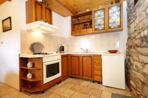 a small kitchen with wooden cabinets and white appliances at Holiday house with WiFi Zrnovo, Korcula - 4876 in Korčula