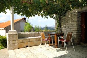 une table et des chaises assises sur une terrasse dans l'établissement Holiday house with WiFi Zrnovo, Korcula - 4876, à Korčula
