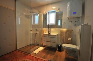uma casa de banho com uma cabina de duche em vidro e um WC. em Apartments and rooms by the sea Banjol, Rab - 5077 em Rab