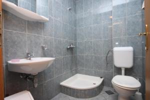 a bathroom with a toilet and a sink at Apartments by the sea Zivogosce - Porat, Makarska - 6699 in Igrane +17 photos