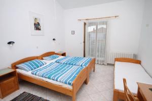 sypialnia z 2 łóżkami, stołem i biurkiem w obiekcie Rooms with a parking space Gornje selo, Solta - 5170 w mieście Grohote