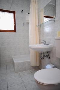 łazienka z toaletą, umywalką i wanną w obiekcie Rooms with a parking space Gornje selo, Solta - 5170 w mieście Grohote