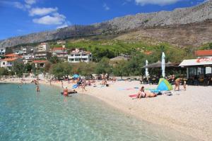 a group of people on a beach in the water at Apartments with a parking space Dugi Rat, Omis - 15417 in Dugi Rat