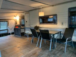 une salle à manger avec une table et des chaises dans une caravane dans l'établissement Sosnowy Village Hel Helska 11, à Hel