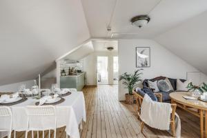 a dining room with a table and a couch at Pensionat Enehall in Båstad
