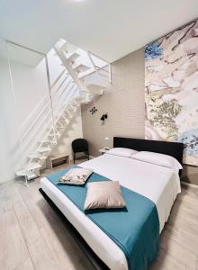 a bedroom with a large bed and a staircase at Le Stanze Guesthouse - di fianco alla Casa di Cura Montanari in Morciano di Romagna
