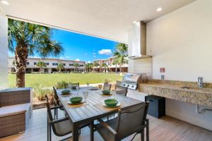 a dining area with a table and chairs and a kitchen at Beautiful townhome Magic Village 1,5 mile to Dis in Orlando