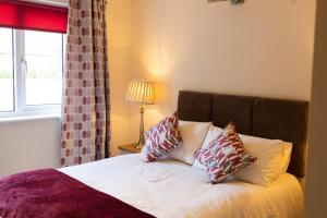 a bedroom with a bed with pillows and a window at The Merry Monk in Ballina