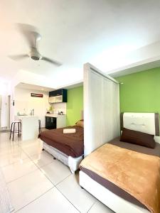a bedroom with two beds and a green wall at Private Studio Viana Court Service Apartment 3 with private parking in Kota Bharu