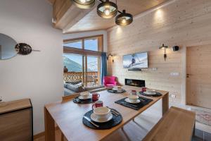 シャテルにあるPerle de Savoie - A402 - Châtel - remises sur les forfaits de skis Châtel ou Portes du soleilのダイニングルーム(テーブル、椅子、暖炉付)