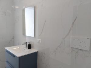 Baño blanco con lavabo y espejo en Appartamento Codroipo Centrale, en Codroipo