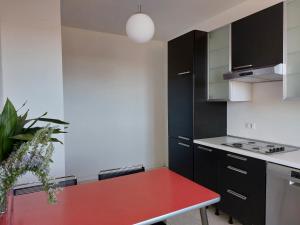 cocina con mesa roja en una habitación en Appartamento Codroipo Centrale, en Codroipo