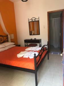1 dormitorio con cama, mesa y espejo en Panorama Rooms en Kamarai