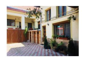 a house with a courtyard with potted plants and a fence at Charlietown in Satu Mare