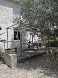 a patio with a table and chairs in front of a house at Jolie maison de ville avec un extérieur au calme - Les Dragons de la Chamoiserie NIORT in Niort