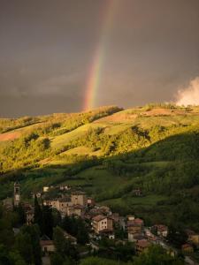 a rainbow over a hill with a town and a city at Cozy & Good Vibes Villa Castana. in Romagnese