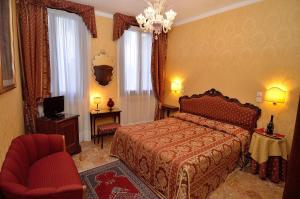 - une chambre avec un lit, une chaise et une télévision dans l'établissement Hotel Da Bruno, à Venise