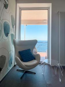 a living room with a chair and a glass table at Mareincasa in Aci Castello