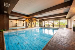 - une grande piscine avec du carrelage bleu dans une maison dans l'établissement Hotel Tannhof, à Oberstdorf