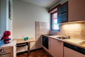 eine kleine Küche mit einer Spüle und einer Theke in der Unterkunft Appartamento Lucino by Quokka 360 - with large terrace in Lugano