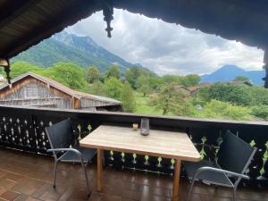 uma mesa e cadeiras numa varanda com vista em Ferienwohnung Heuberg em Nussdorf am Inn