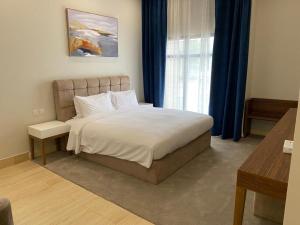 a bedroom with a large bed and a window at Half Moon Al Khobar Resort in Half Moon Bay