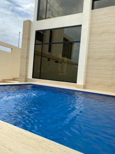 a house with a swimming pool in front of a house at Half Moon Al Khobar Resort in Half Moon Bay