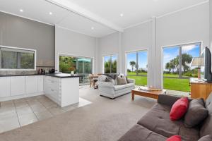 a living room with a couch and a kitchen at Sea View Cottage - Ruakaka Holiday Cottage in Ruakaka