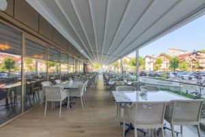 un restaurante con mesas y sillas en un balcón en Bacolux Koralio, Eforie Nord en Eforie Nord