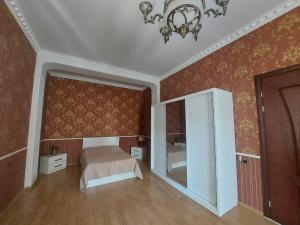 sypialnia z łóżkiem, lustrem i żyrandolem w obiekcie Hotel Florencia w Mcchecie