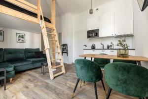 salon z łóżkiem na podwyższeniu oraz stołem i krzesłami w obiekcie Homewell Apartments Wilson Park II w Poznaniu