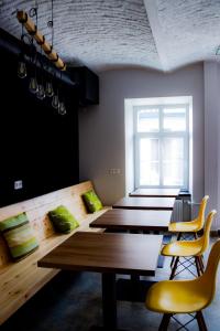 Zimmer mit Holztischen, gelben Stühlen und einem Fenster in der Unterkunft FOKA Hostel in Breslau