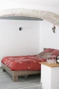 a bedroom with a red bed in a white wall at Rully house in Rully