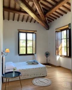 a bedroom with a bed and a table and windows at Abbazia Sette Frati Agriturismo Fratres in Pietrafitta