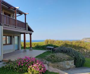 dom z patio i kwiatami przed nim w obiekcie VILLA&MAR LANGRE BEACH w mieście Langre