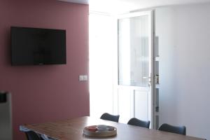 a dining room table with chairs and a television on a wall at Rully house in Rully