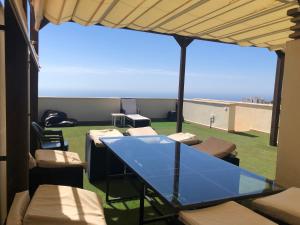 a glass table on a balcony with a view of the ocean at Ático duplex en Benalmádena vistas al mar y montaña dos habitaciones in Benalmádena