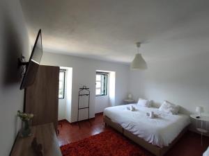 - une chambre blanche avec un lit et un lavabo dans l'établissement Casa do Rio, à Constância