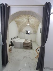 una camera con letto e parete in pietra di RE ARTU' a Pulsano
